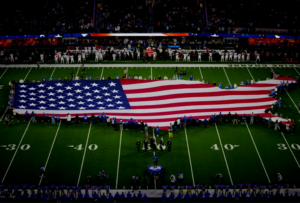A general overall view of a United States flag on the field as saxophonist Michael Phillips performs the national anthem before the game between the Arizona Cardinals and the Los Angeles Rams at SoFi Stadium. (Credit: Kirby Lee-Imagn Images)