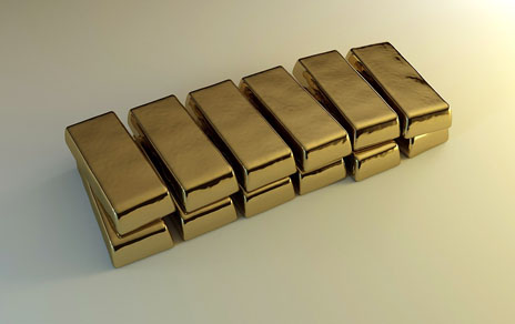 Gold bars sitting on a white surface