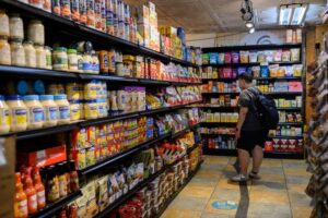 Grocery Store Aisle with Man wearing Backpack on Tile Floor